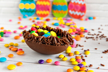 Fototapeta na wymiar Delicious chocolate-filled easter egg, easter concept on candy background.