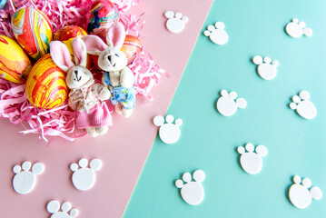 Easter decoration on pink and green background, easter eggs and cloth bunny.