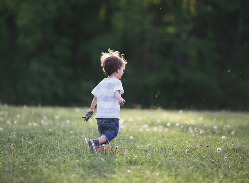 young boy runs in field
