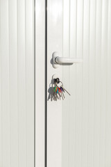 set of colored keys placed in the lock of a door to open or close the office building