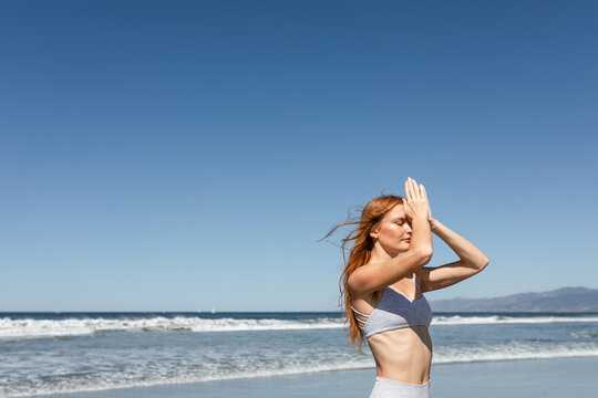Woman Exercises On The Beach