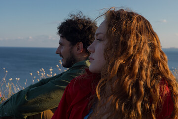 Naklejka premium side view of a couple at sea background 