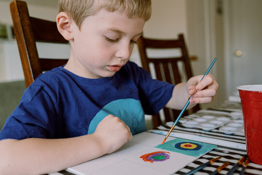 A little boy paints a picture.