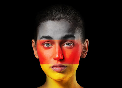 Young woman in colors of national flag of Germany on dark background