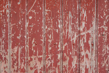 Rough background texture, showing a weathered and scratched wooden door with peeling red paint and exposed wooden boards underneath