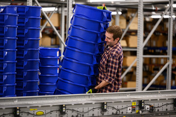 Worker lifts containers at warehouse