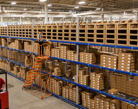 Worker scans box of  merchandise at  Warehouse