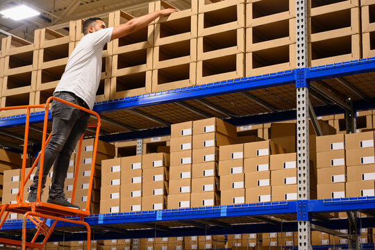 Man on ladder Picking Product at E-Commerce Warehouse
