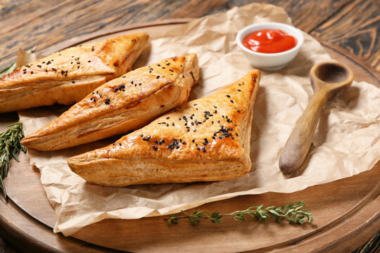 Board with tasty Uzbek samsa on table