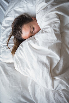 Woman sleeping on white sheets
