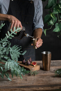 Young Mixologist Pouring Liquor In A Jigger 