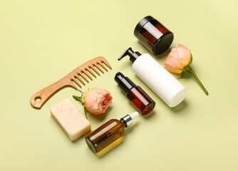 Obraz premium Composition with cosmetic products, hair comb and rose flowers on green background