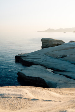 Large curvy rock cliff in shadow in Sarakiniko beach