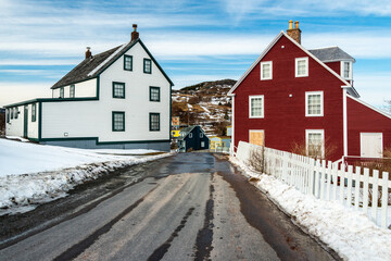 Trinity, Newfoundland, Canada - March 2022: A street view of historic Trinity with large wooden colorful houses. 19th century three storey buildings with single hung windows, dormers, and steep roofs.