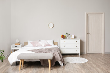 Interior of light bedroom with chest of drawers and fruit basket