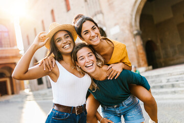 Multiethnic group of three happy young women having fun on summer vacation - Diverse female friends...