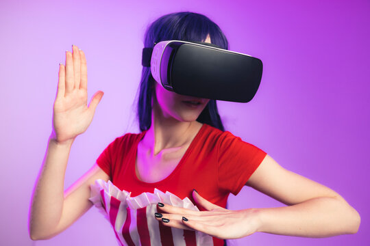 Attractive dark haired woman experiencing virtual reality magenta background isolated playing arcade game . High quality photo