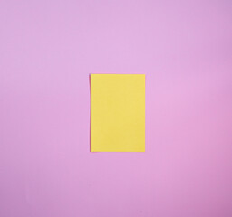 Obraz na płótnie Canvas Yellow paper note over a pink background. Reminder paper