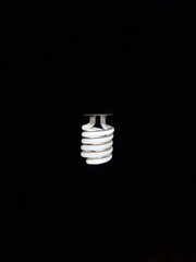 a glowing spiral incandescent lamp photographed against a dark background