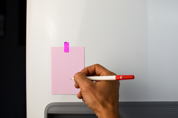 Pink note reminder paper sticked in freezer, fridge with glitter pink sticker. Refrigerator message. Hand writing with red pen