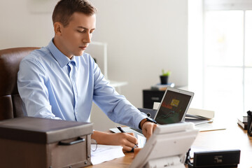 Young male notary public working in office