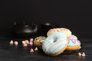 Different sweet donuts on dark background