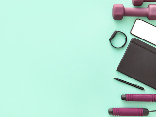 Set of sports equipment, notebook and mobile phone on color background