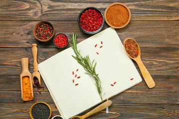 Composition with open notebook and aromatic spices on wooden background