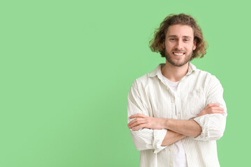 Smiling young man in shirt on green background