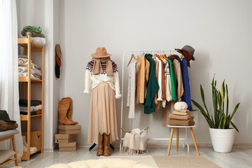 Interior of light dressing room with mannequin, rack and warm sweaters