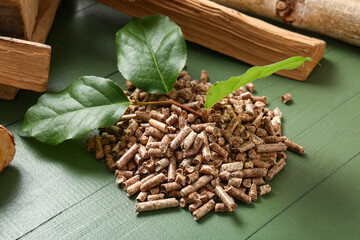 Fototapeta premium Pile of wood pellets on color wooden background, closeup