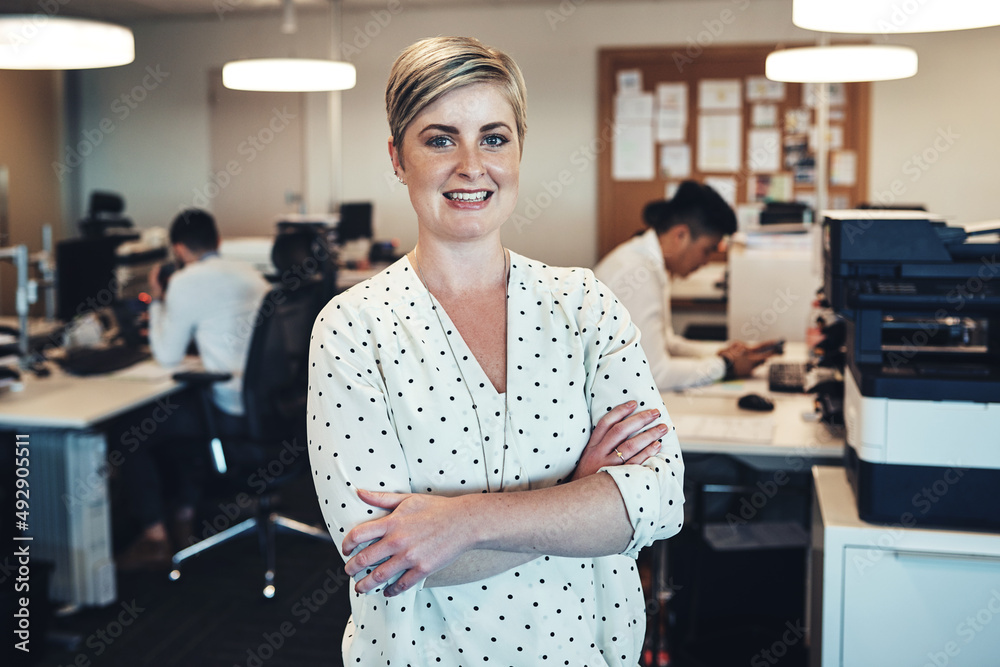 Poster shes here to implement structure in the office. portrait of a businesswoman in the office while her 