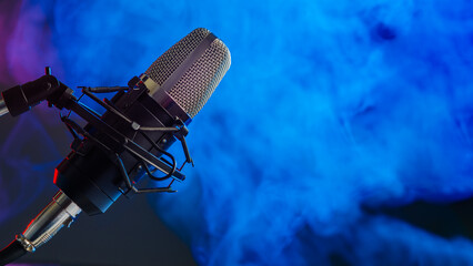 Studio microphone on blue smoke background. Vocal, blogger and sound recording concept.Background for karaoke and recording studio - 492905514