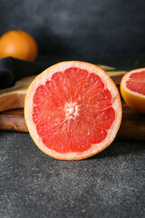 Fototapeta na wymiar Tasty cut grapefruit on dark background