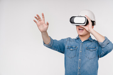 Architect construction worker asian young man student using VR glasses, touching with a hand copy space free space, playing virtual video games isolated on white background