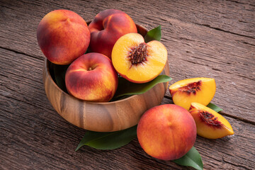 Yellow Peach with slice in wooden basket, Fresh Yellow Peach fruit in wooden bowl on wooden...