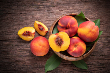 Yellow Peach with slice in wooden basket, Fresh Yellow Peach fruit in wooden bowl on wooden background.