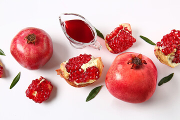 Tasty pomegranates and gravy boat with jam on white background