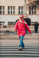 A Muslim woman wearing a hijab walks the streets of the city in a modern outfit combined with sunglasses. Selective focus