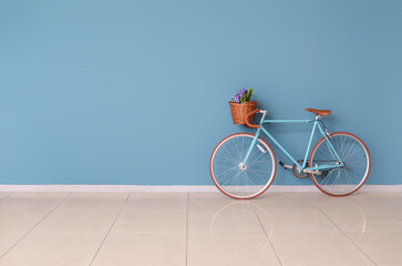 Modern bicycle near blue wall in empty room