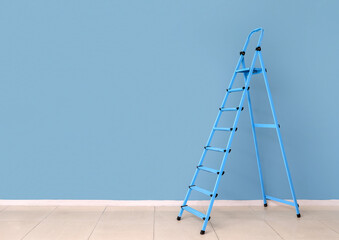 Maintenance ladder near blue wall in empty room © Pixel-Shot