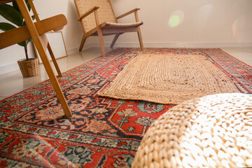 Stylish carpets on floor in light room, closeup