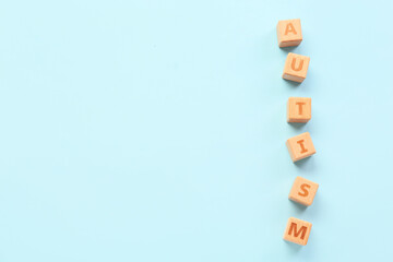 Wooden cubes with word AUTISM on blue background