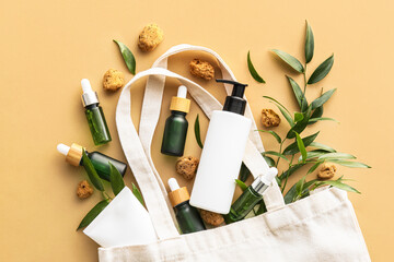 Shopping bag with natural cosmetics on color background