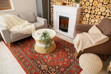 Interior of cozy living room with vintage carpet, table and fireplace