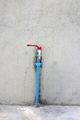 Faucet on cement wall background.