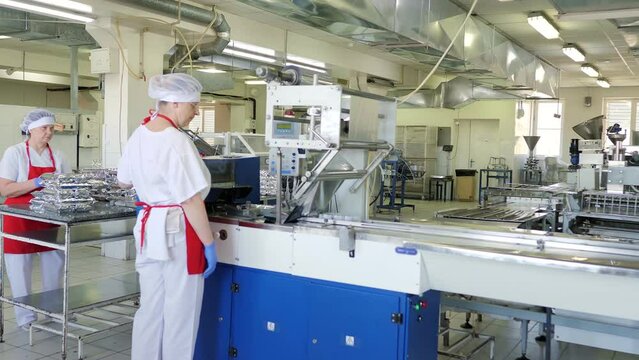 The plastic packaging machine on the production line packs food products. Humanitarian aid. Packaging of products at the enterprise.Robotic Production Line