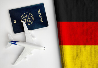 Flag of Germany with passport and toy airplane. Flight travel concept
