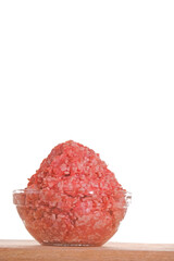 minced pork. fresh raw minced meat close-up in a transparent cup on a wooden table isolated on white background.Minced meat texture.Meat products.Ground fresh meat close-up. 