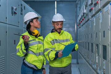 Two worker checking panel in electrical control room on substation. worker checking in medium voltage control room.